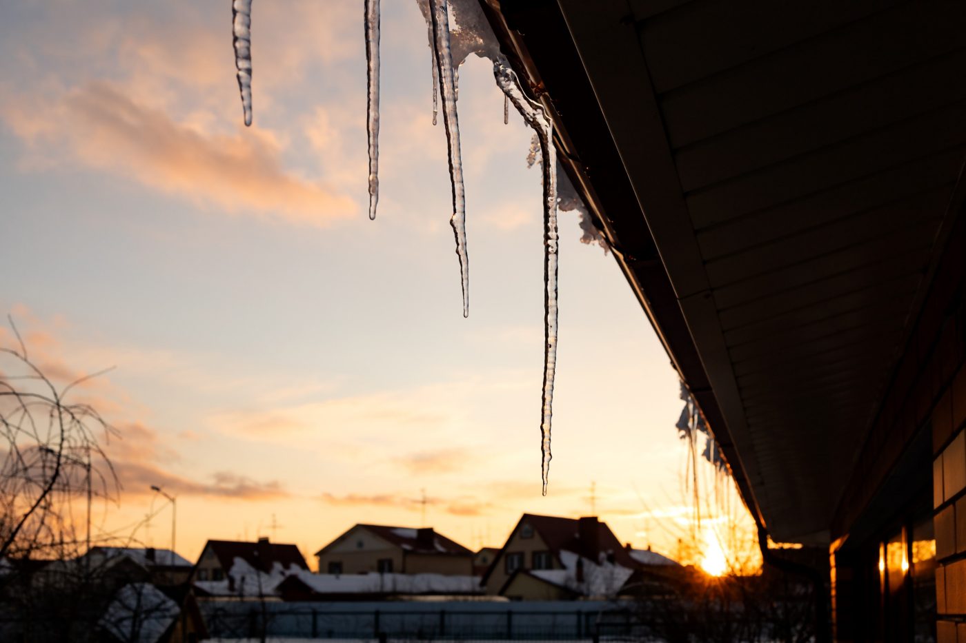 icicles hanging from the edge of the roof dripping water