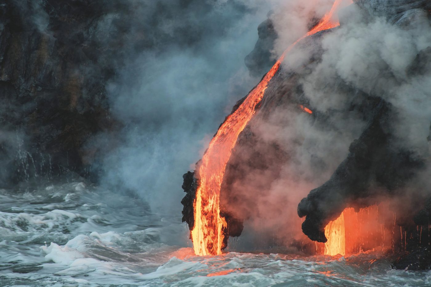 Molten lava flowing into the Pacific Ocean on Big Island of Hawaii at sunrise